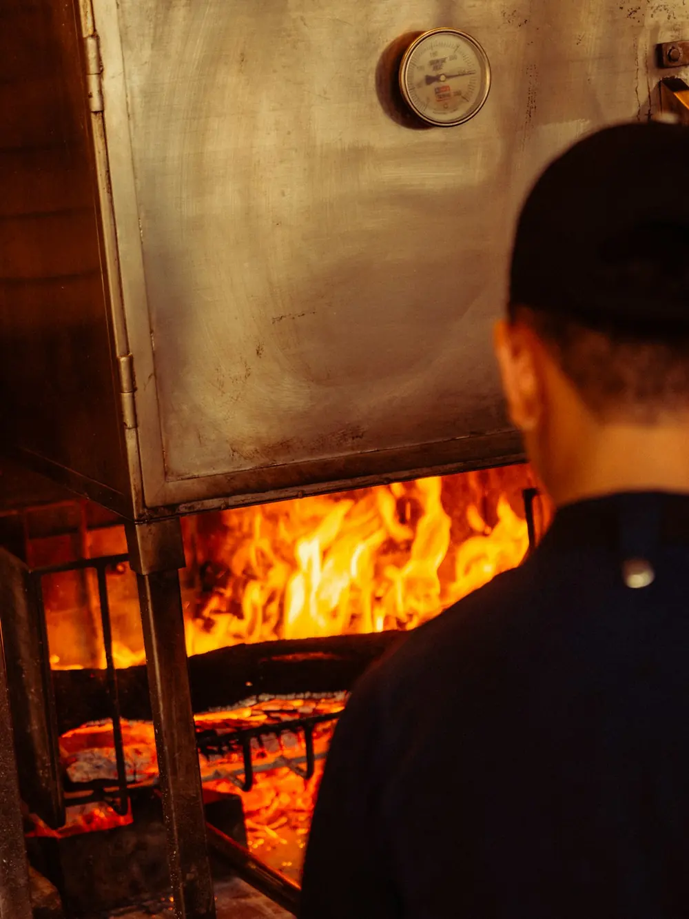 Cocinero trabajando junto al fuego de leña